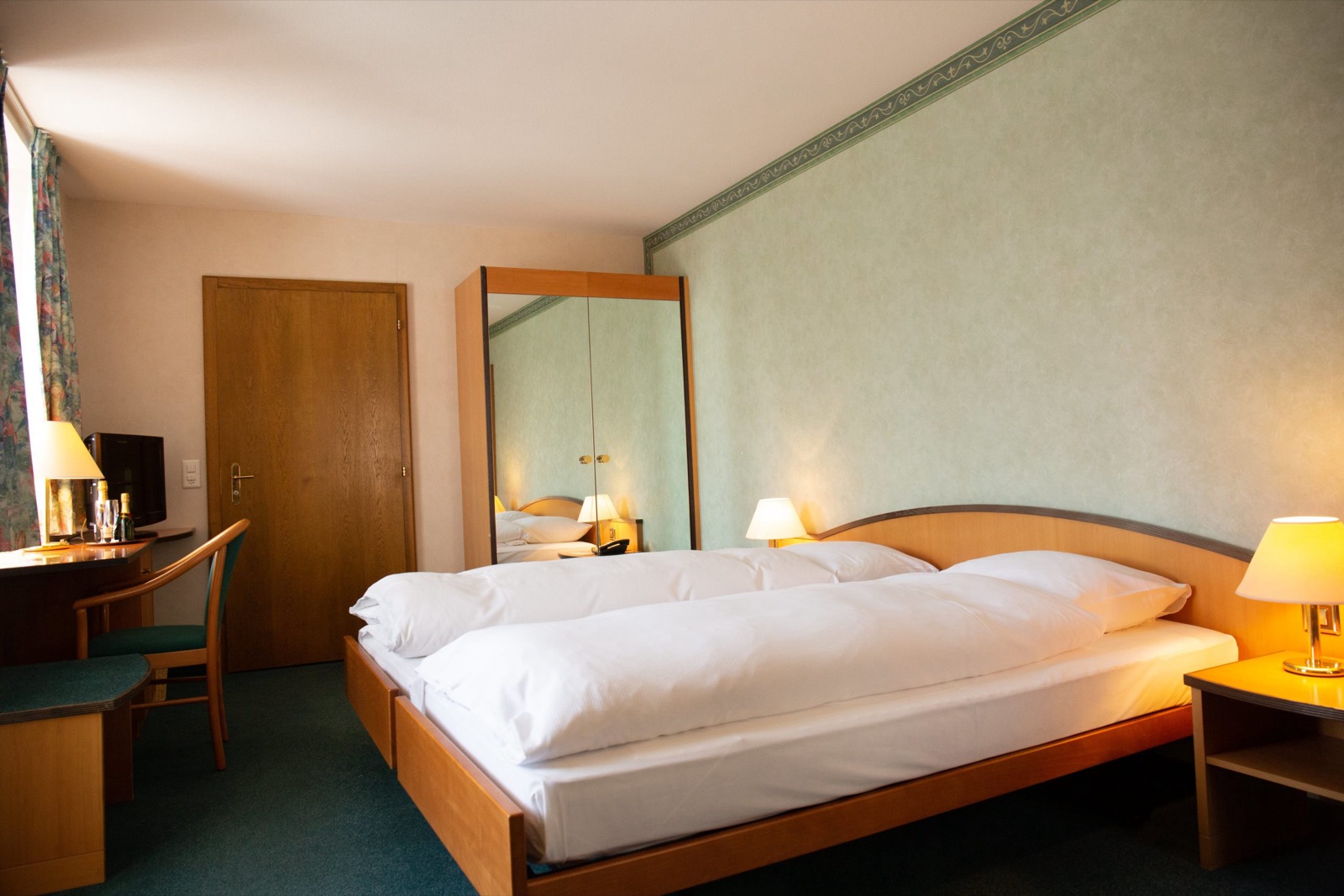 Grand lit d’une chambre de l’Hôtel des Alpes