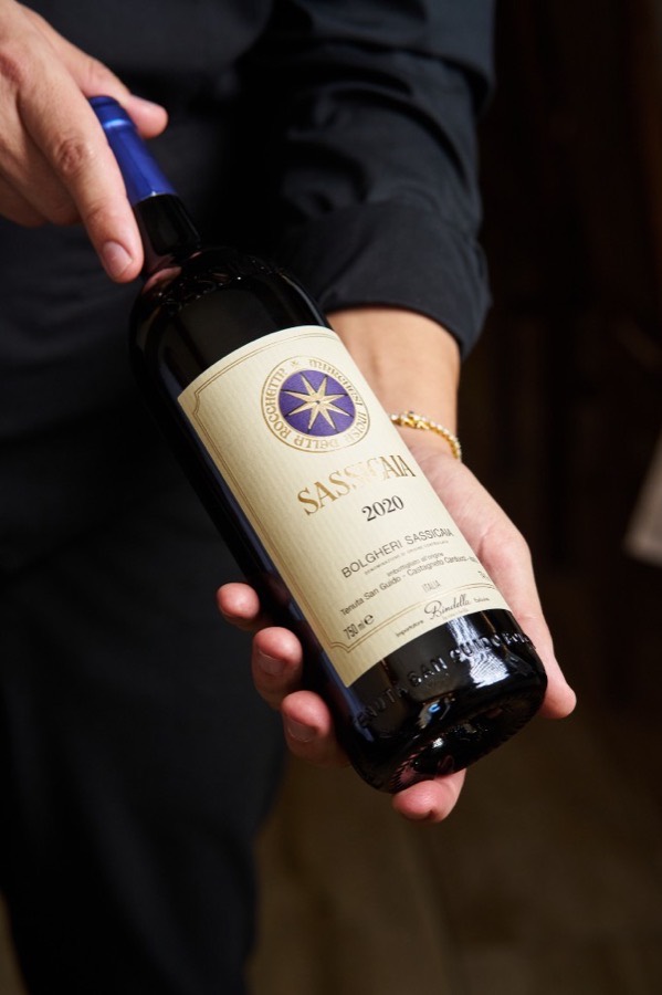 Bouteille de Sassicaia 2020, tenue à deux mains